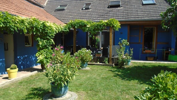 A courtyard with potted plants, a seating area, and a building with a tiled roof. - To explore the Christmas Markets in Alsace! (Neuf-Brisach)