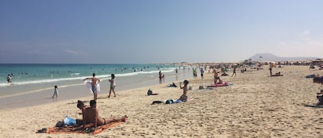 Una playa cerca, sillas reclinables de playa, toallas de playa