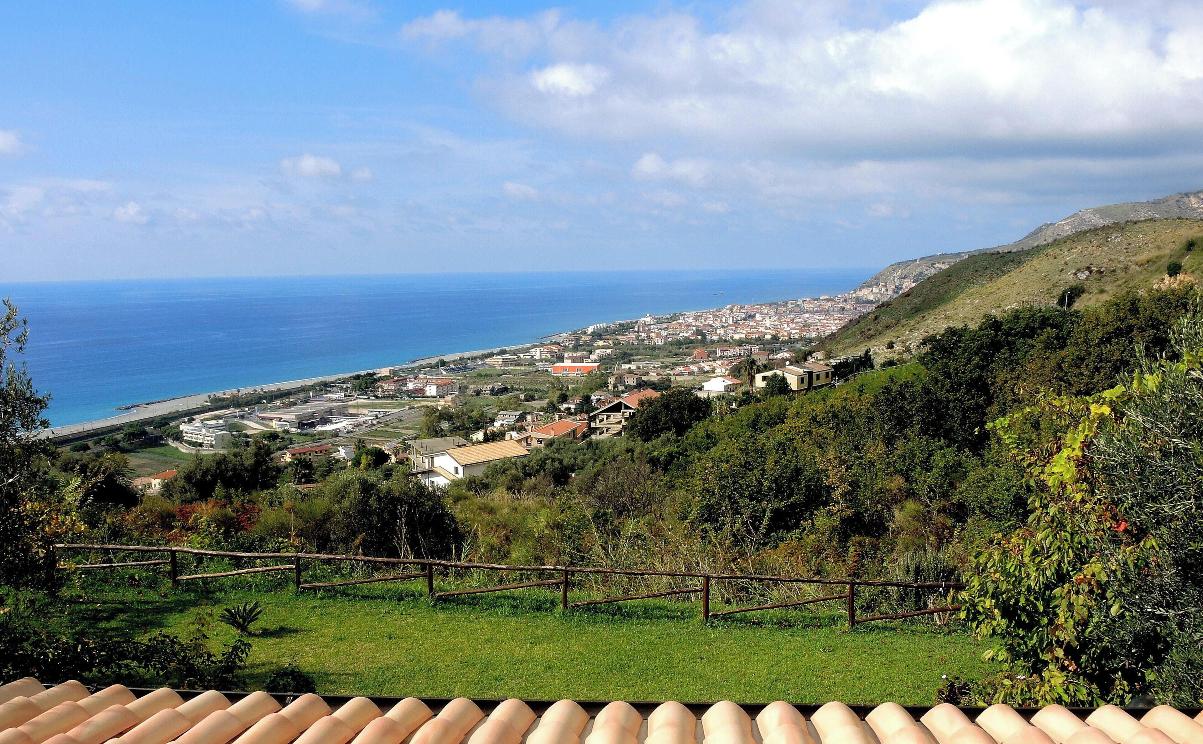 Un pueblo costero con vista al mar y a las colinas.