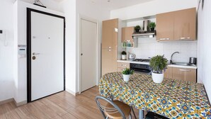 Cocina compacta con una mesa de comedor, sillas y plantas en macetas.