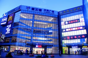 A multi-story commercial building with various storefronts, including a McDonald's and a cinema.