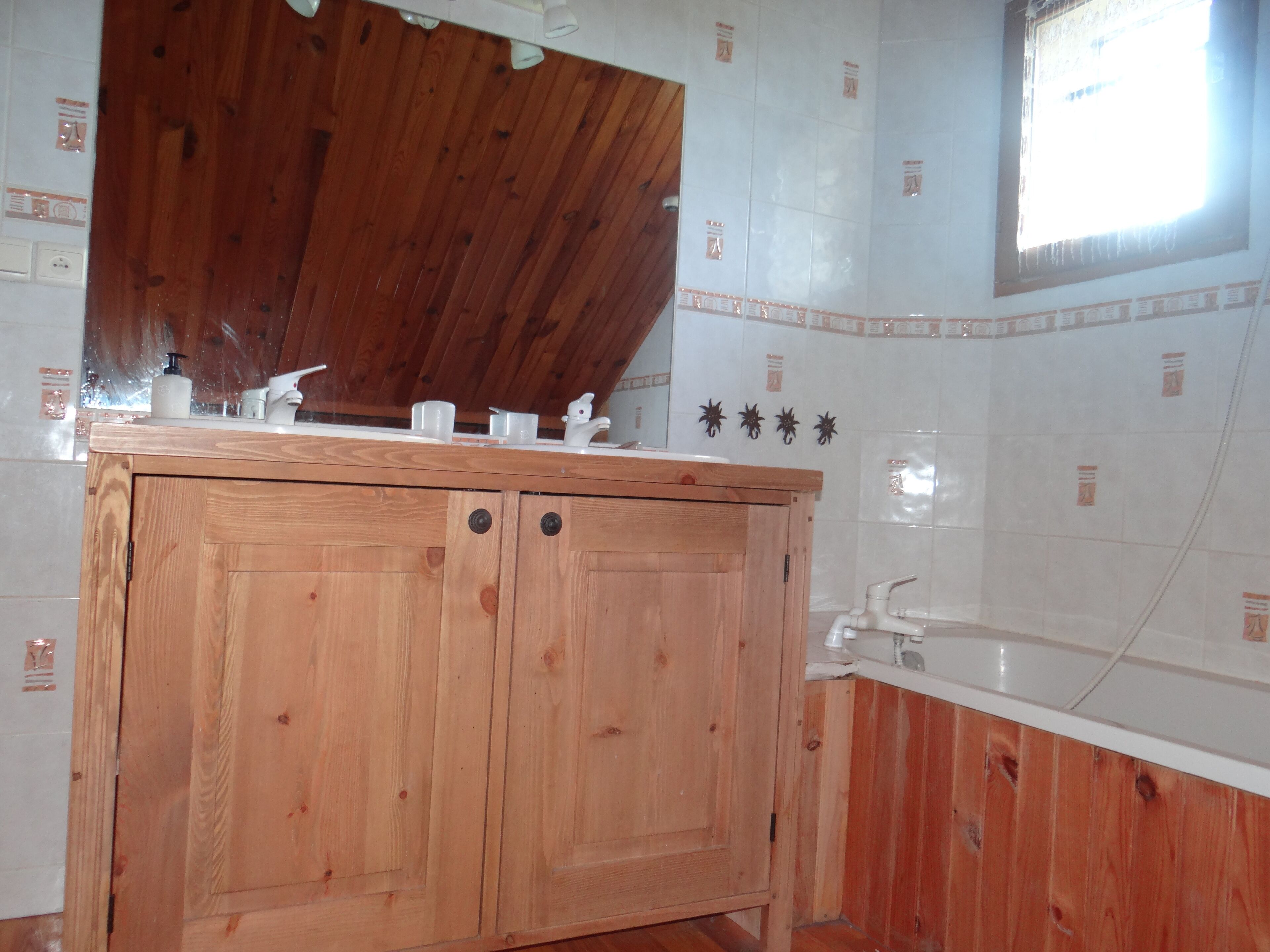 Ein Holzbadezimmermöbel mit Waschbecken und Badewanne.