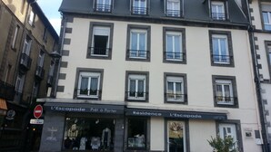 Ein mehrstöckiges Gebäude mit einer Ladenfläche im Erdgeschoss, auf der 
