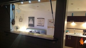 A kitchen with a sink, cabinets, and a fan.