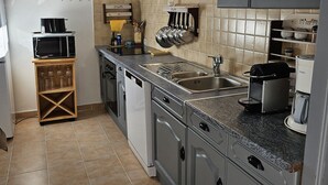 A kitchen with grey cabinets, a stainless steel sink, a microwave, and a coffee maker. - Sarrians rental for 4 people, pets welcome.  (Sarrians)