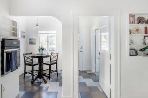 A kitchen with a dining table and chairs, a refrigerator, and a window with a view. - Historic 4BR Alameda Victorian Near Beach & SF (Alameda)