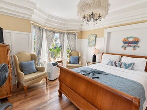 A hotel room with a large bed, two armchairs, a desk, and a chandelier. - Historic 4BR Alameda Victorian Near Beach & SF (Alameda)