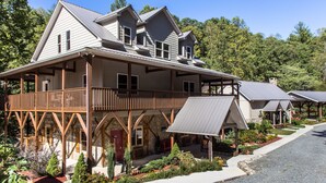 A large, two-story house with a covered porch and a small garden in front. - Cedar Suite: Mountain Getaway overlooking The Roaring River on the vineyard (Traphill)