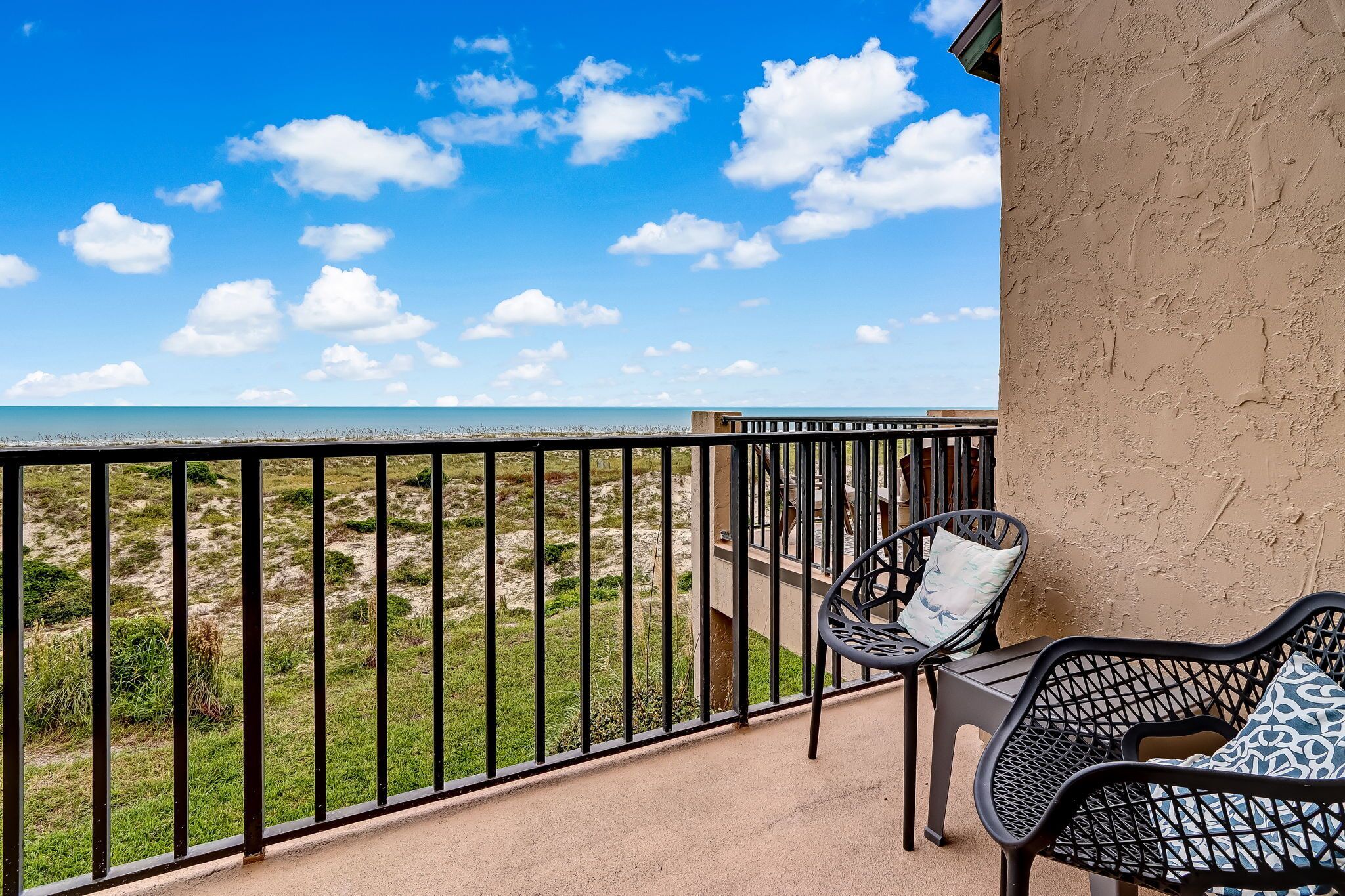 Un balcon avec vue sur la plage et l’océan.
