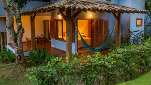 A two-story building with a covered patio area, wooden flooring, and a hammock. - Charm Bahia Residências (Porto Seguro)