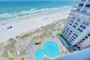 A hotel with a pool area, beach access, and a view of the ocean.