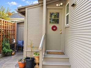 A residential entryway with a beige door, a small window, and a red wreath. - Spacious Alameda Cottage with Private Garden (Alameda)