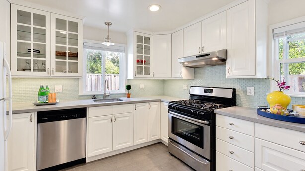 A modern kitchen with white cabinetry, stainless steel appliances, and a window providing natural light. - Spacious Alameda Cottage with Private Garden (Alameda)