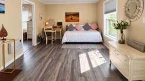 A bedroom with a bed, desk, dresser, and a painting on the wall. - Spacious Alameda Cottage with Private Garden (Alameda)
