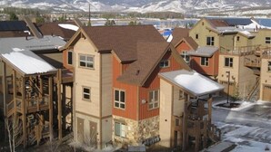 A residential area with houses featuring a mix of wooden and brick exteriors, some with visible balconies and a mountainous backdrop. - Luxury Condo, Private Hot Tub, Perfectly Located (Frisco)