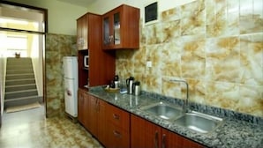 A kitchen with granite countertops, wooden cabinets, and a tiled backsplash.