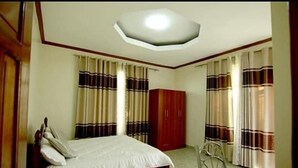A bedroom with a bed, a wardrobe, a desk, and a chair.