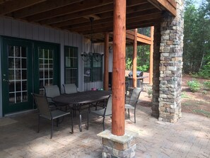 An outdoor patio with a stone column, a wooden pergola, and a grill area. - Main Lake Log Home Retreat - pizza oven, fire pit, kayaks, SUP, pontoon (Henrico)