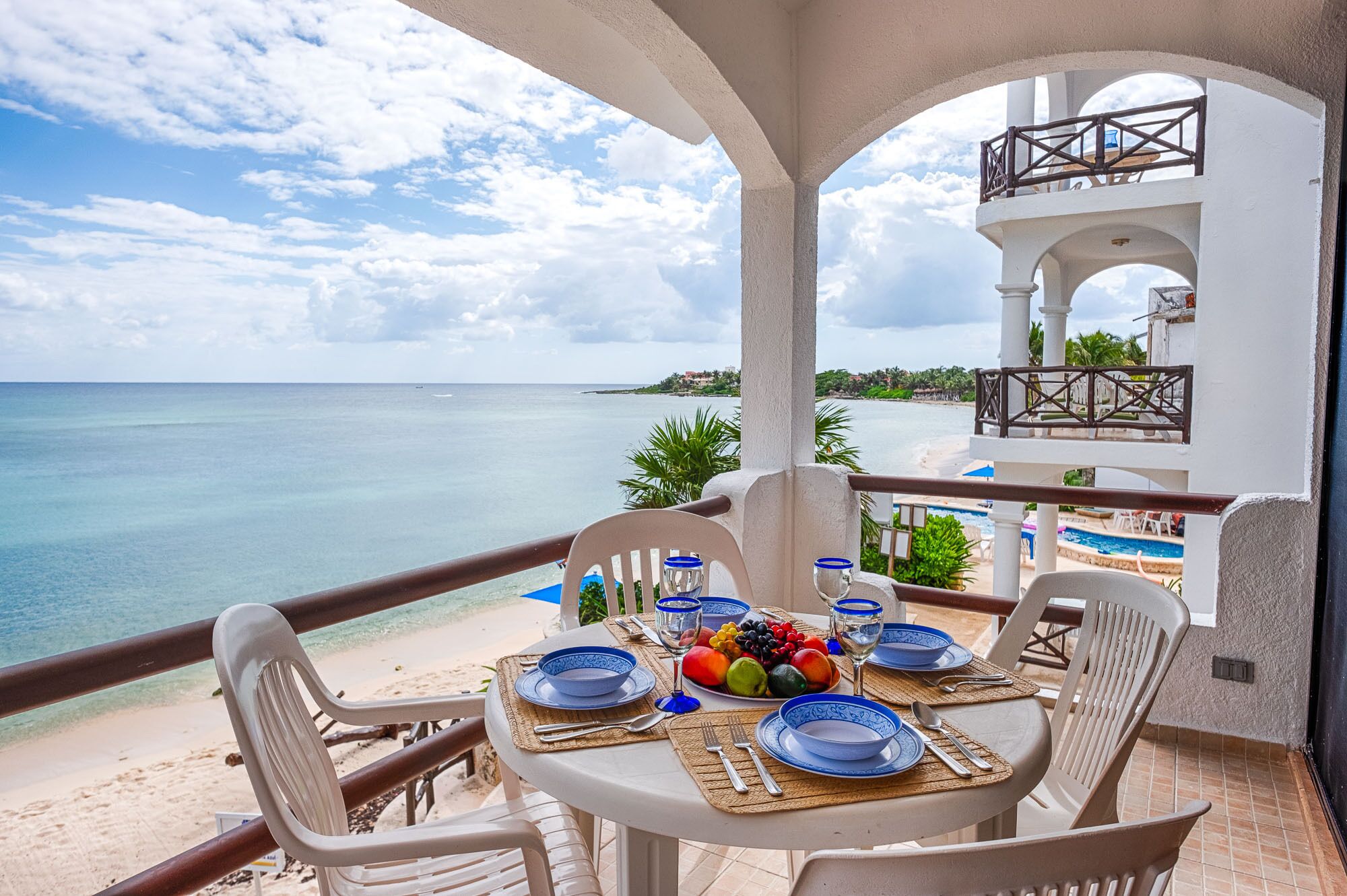 A table set for two with a view of the beach and ocean.