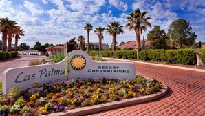 A sign for Las Palmas Resort Condominiums with a landscaped garden in front. - Paradise Awaits You In This Beautiful Las Palmas Unit. (St George)