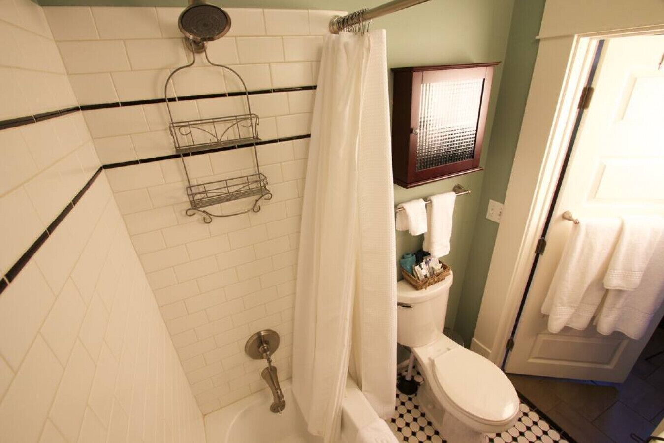 Een badkamer met een douche, toilet en een handdoekhouder.