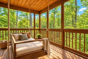 A wooden deck with a bed, pillows, a plant, and a basket. - Glori's Retreat - $560 of FREE  tickets for each paid day (Pigeon Forge)