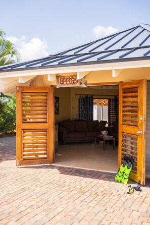 A wooden door with a sign reading "Coffee" and a pair of green diving fins on the ground. - Ocean Villa With Pool, Getaway (Duncans)