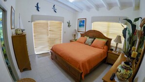 A bedroom with a wooden bed, a nightstand, a lamp, a vase, and a wicker basket. - DUPLEX IN DUCK KEY, 2 Bedroom /2 Bath  w/40' Dock,  Trailer Storage Incl. (Marathon)