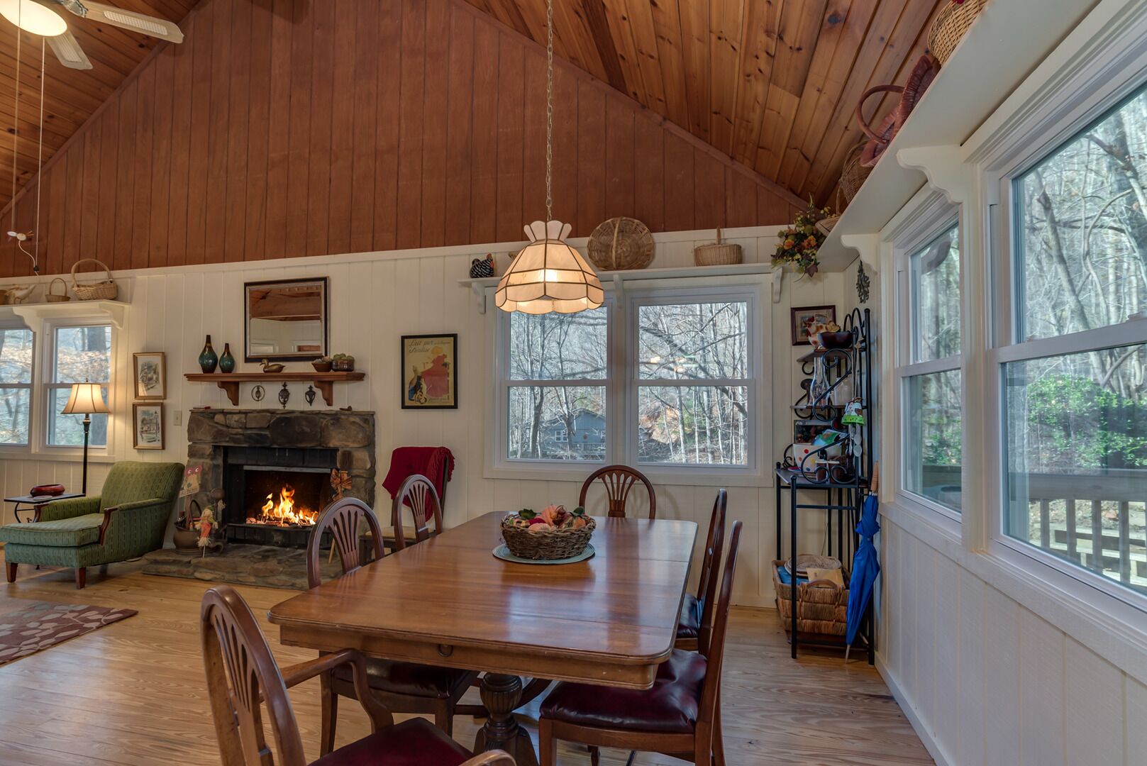 Un salon chaleureux avec une cheminée, un plafond en bois et de grandes fenêtres.