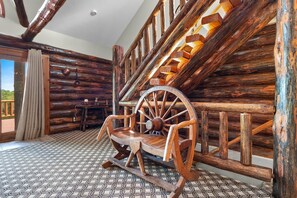 A rustic interior with a wooden rocking chair, a spinning wheel, and a patterned floor. - Full Log Lodge 3 night minimum, 2 night minimum October- April, Pet Friendly (Lakewood)