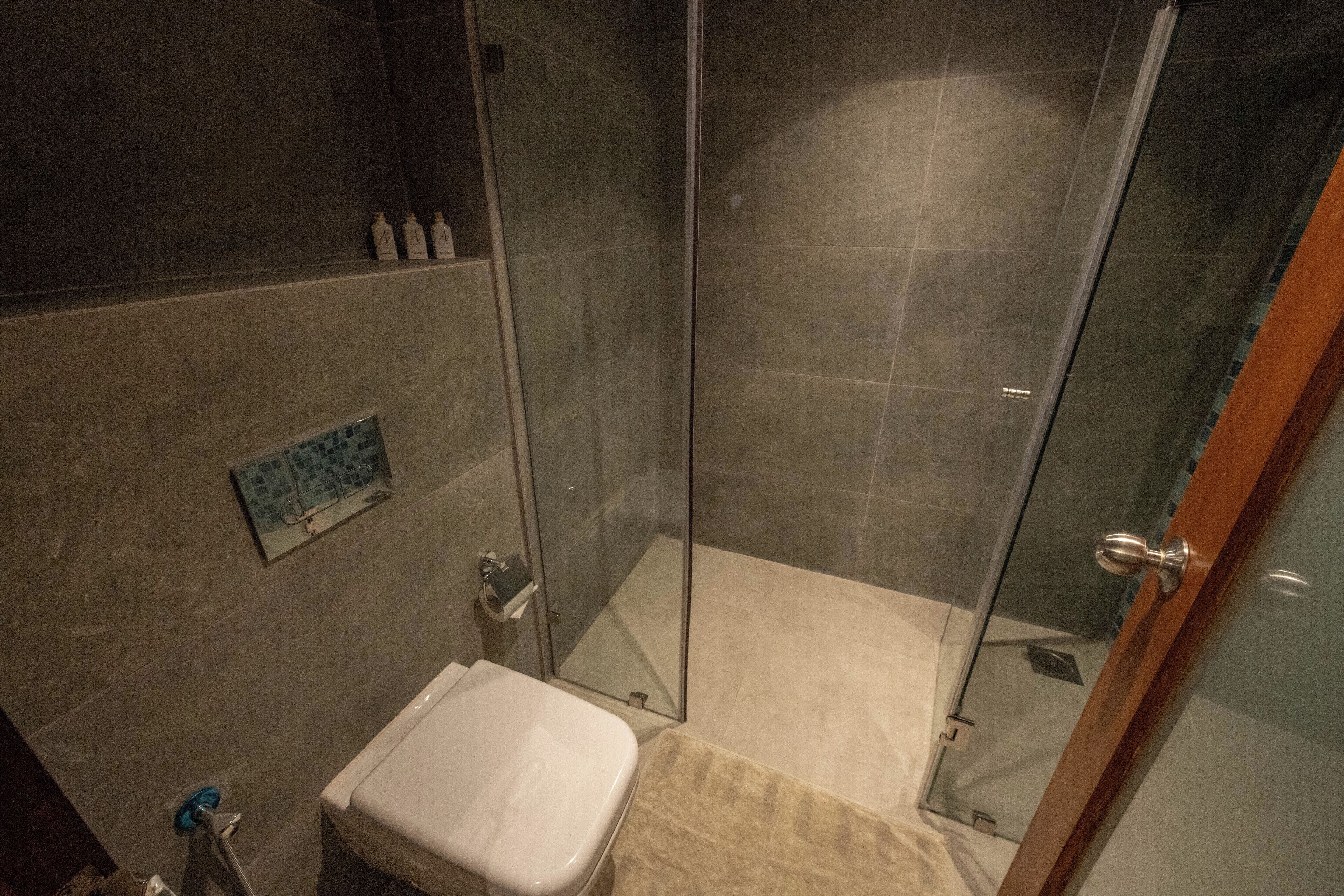 Un baño con cabina de ducha de vidrio, inodoro y lavabo.