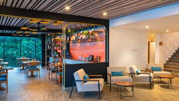 A modern interior with a bar area, seating, and a staircase.