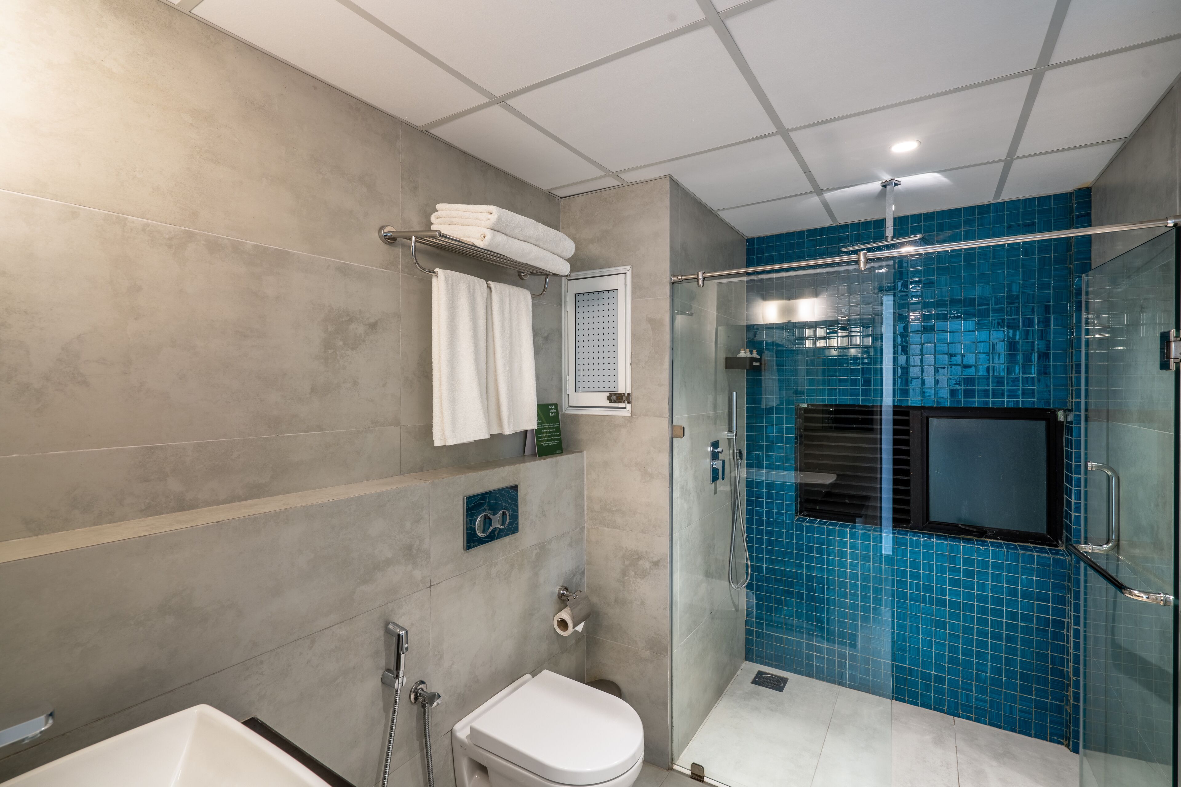 Un baño moderno con cabina de ducha de vidrio, un inodoro blanco y una bañera.