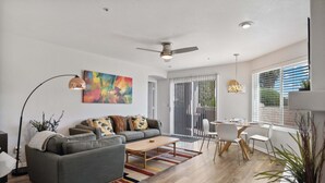 A modern living room with a sofa, coffee table, and dining area.