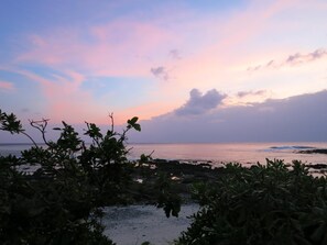A beach with rocky foreground and a view of the ocean at sunset. - Star-Moon B&B (Lyudao)