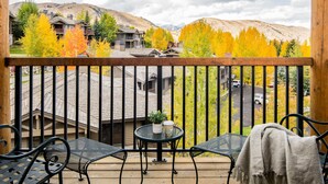 A wooden deck with outdoor furniture, a view of a mountainous landscape, and autumn-colored trees. - Outpost: Love Ridge 241 - Freestanding, AC! (Jackson)