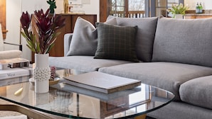 A modern living room with a grey sectional sofa, a glass coffee table, and a framed artwork on the wall. - Outpost: Love Ridge 241 - Freestanding, AC! (Jackson)