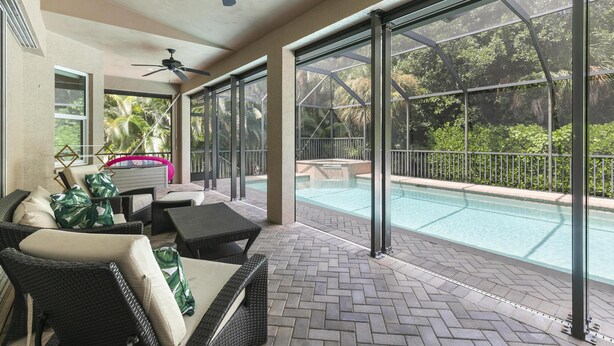 A covered outdoor area with wicker furniture, a pool, and large windows. - 4Br Pristine Home Sleeps 6 Adu - Heated Pool + Spa - Private backyard (Marco Island)