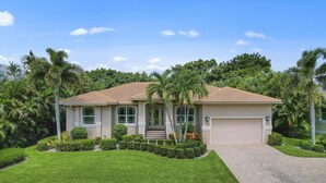 A single-story house with a tiled roof, a front porch, and a garage. - 4Br Pristine Home Sleeps 6 Adu - Heated Pool + Spa - Private backyard (Marco Island)