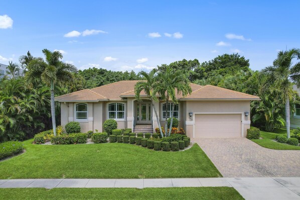 A single-story house with a tiled roof, a front porch, and a garage.