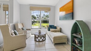 A modern living room with a sofa, armchairs, a coffee table, and a bookshelf. - 4Br Pristine Home Sleeps 6 Adu - Heated Pool + Spa - Private backyard (Marco Island)