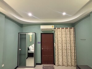 A room with a sliding door, a closed door, and a window with curtains. - Huaisai Hotel (Nong Khae)