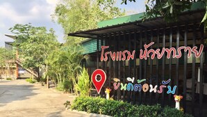 A building with a green roof and a sign with Thai text. - Huaisai Hotel (Nong Khae)