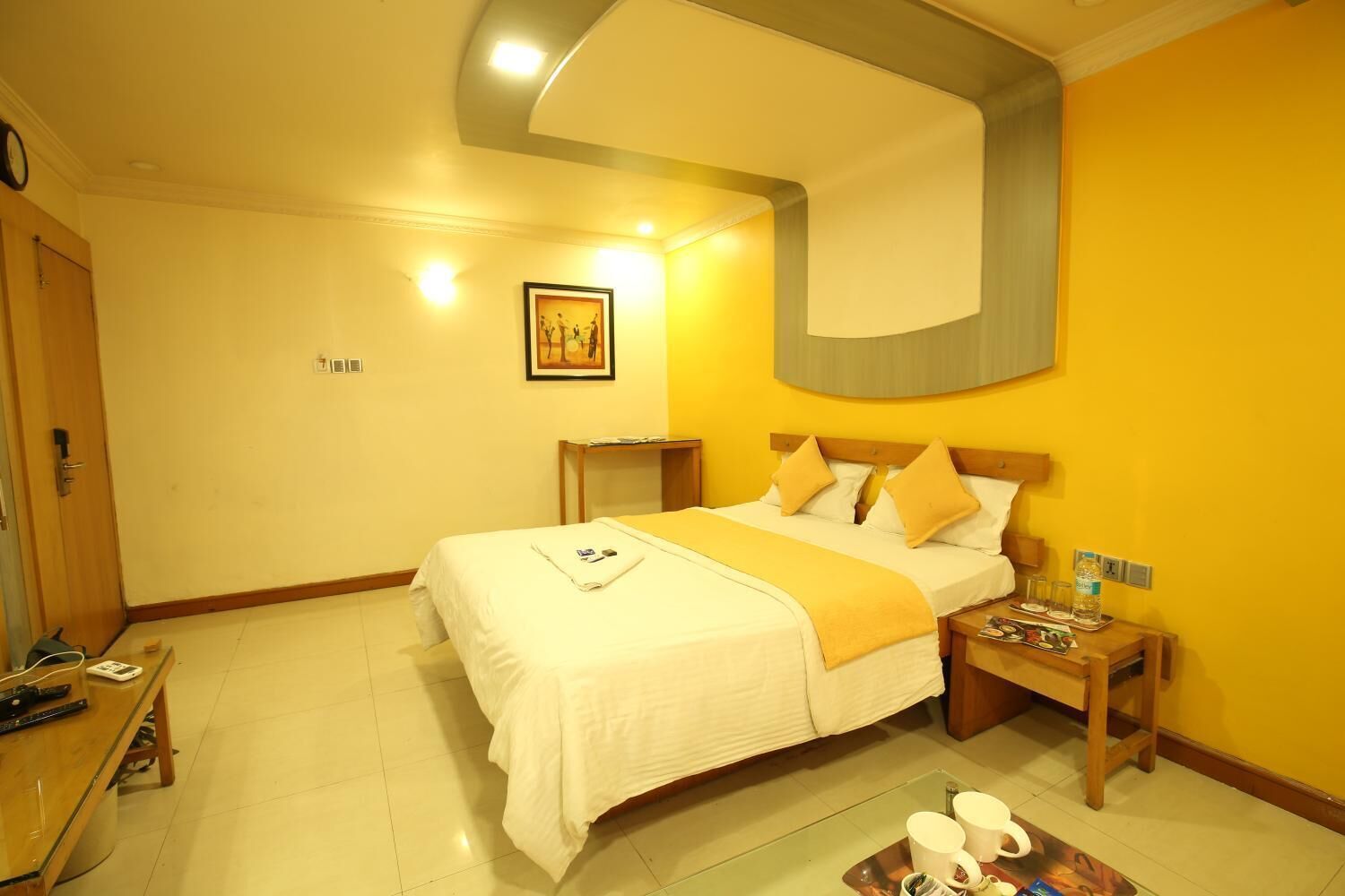 A hotel room with a bed, bedside tables, a desk, and a chair.