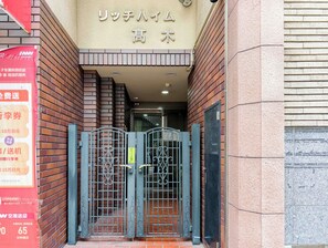 A building entrance with a brick facade and a metal gate.