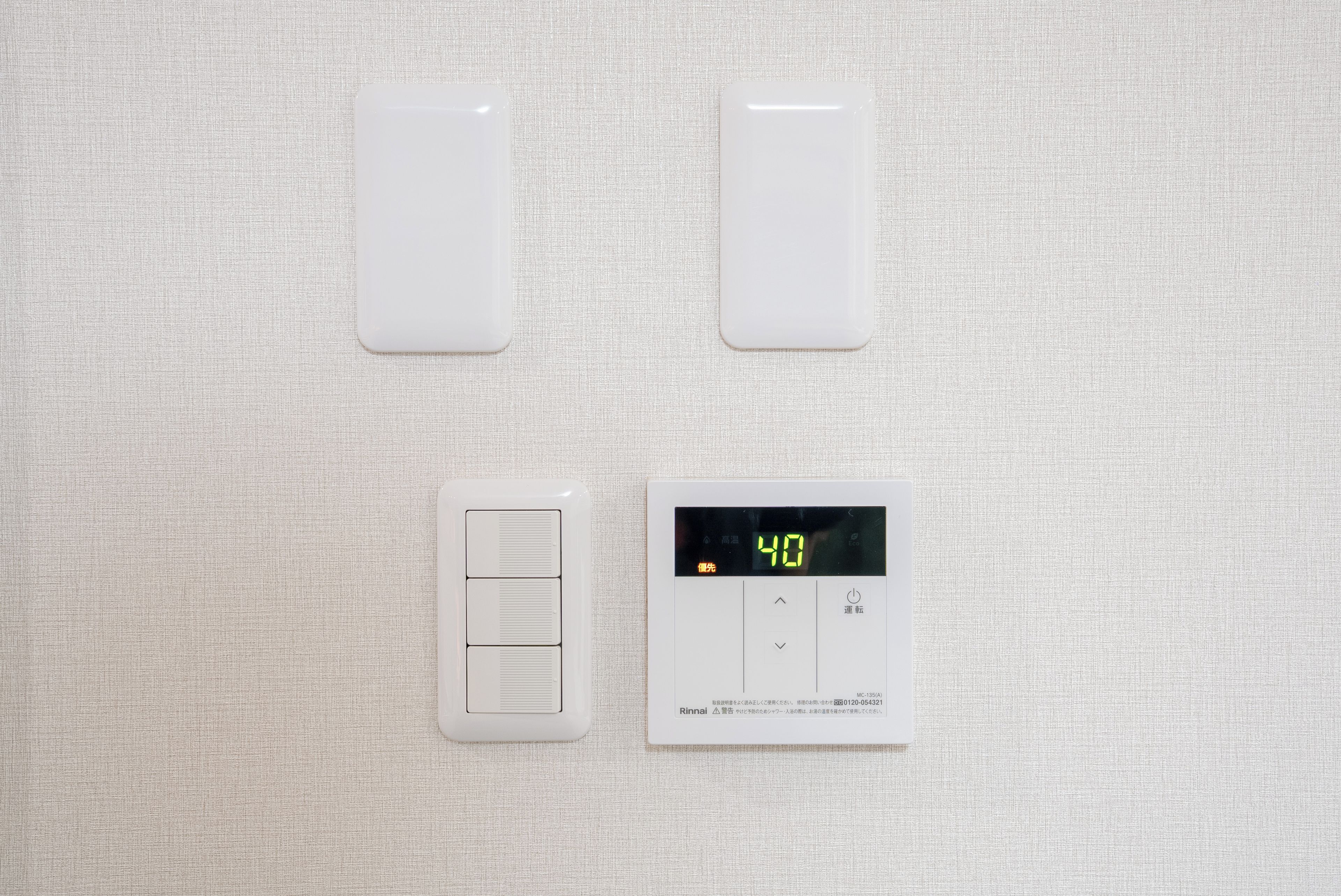 A thermostat with a digital display set to 40 degrees, a wall-mounted control panel, and a vent.