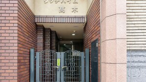 Fachada de edificio de ladrillo con un letrero en japonés.
