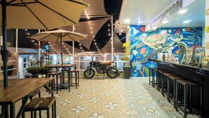 Un restaurante con terraza, un mural y una zona de recepción.