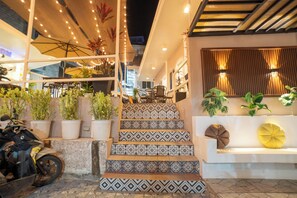 Una escalera con baldosas estampadas que lleva a una zona de estar con cojines.