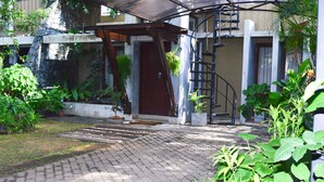 A paved entrance with a wooden door, a concrete staircase, and potted plants. - Villa Tulip Garden (Anuradhapura)